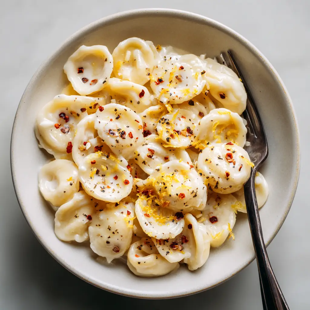 A delicious bowl of lemon cream sauce for pasta, garnished with fresh herbs and ready to eat.