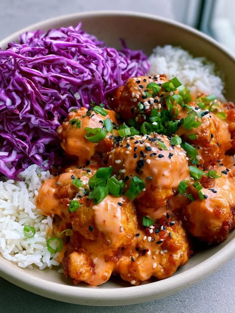 Draufsicht auf die Bang Bang Chicken Bowl mit dem Fokus auf die glänzende Sauce und den knackigen Rotkohl.