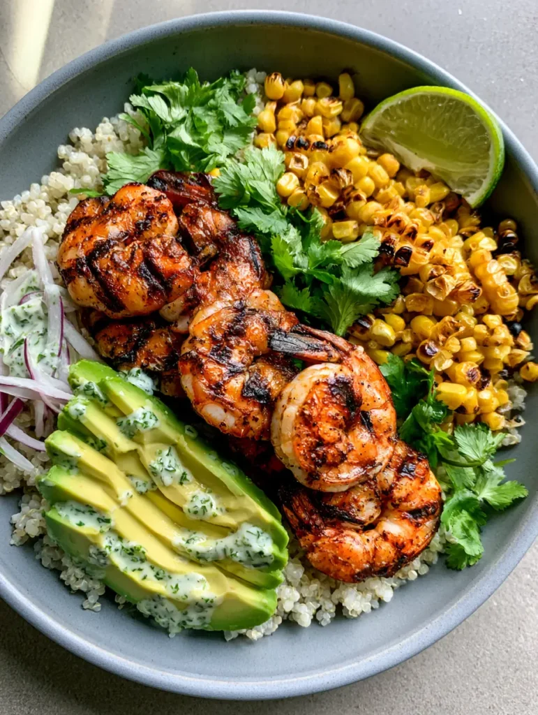 Garnelen Bowl mit Grill-Aroma & cremigen Limetten-Dressing 1 Zwei matte graue Schalen gefüllt mit einer gesunden Garnelen Bowl und Limetten-Dressing.