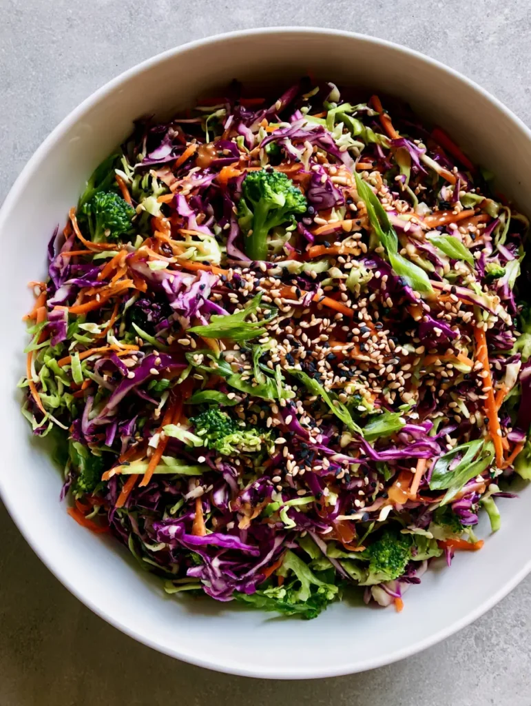 Asiatischer Krautsalat: Das ultimative Rezept für Knackigkeit & Aroma 1 Asiatischer Krautsalat serviert in einer minimalistischen weißen Schüssel auf einem grauen Steinuntergrund.