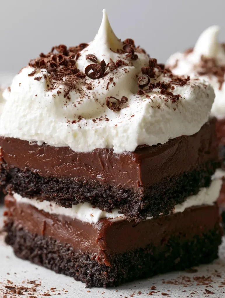 Schokoladen-Schnitten ohne Backen: Das ultimative cremige Dessert-Rezept 1 Quadratisch geschnittene Schokoladen-Schnitten ohne Backen mit Schokoraspeln dekoriert.