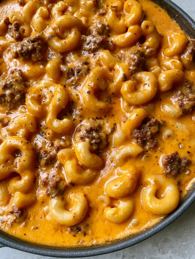 Nahaufnahme der One-Pot Nudel-Hack-Pfanne mit Fokus auf die glänzende Käsesauce und das Hackfleisch.