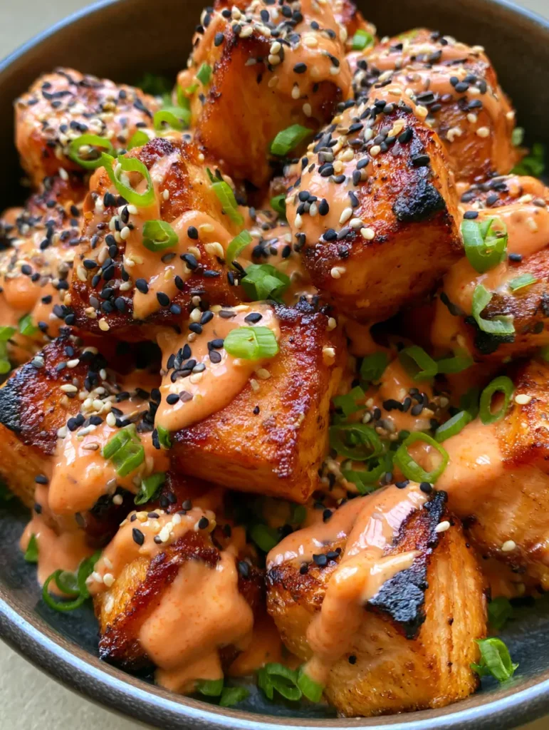 Bang Bang Lachs: Knusprige Lachs-Bites in cremiger Sriracha-Mayo 1 Draufsicht auf servierfertigen Bang Bang Lachs in einer Schale mit reichlich Frühlingszwiebeln garniert.